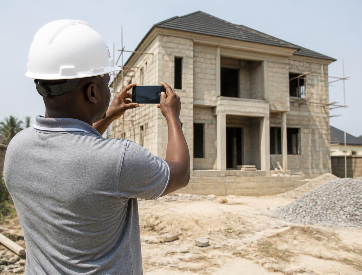 An inspector photographing progress on a building project in Nigeria